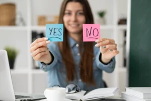 smiling woman holding to sticky notes up with the words yes and no